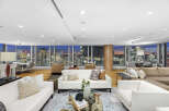 This luxurious penthouse boasts breathtaking panoramic city views from its expansive floor-to-ceiling windows, creating a bright and airy atmosphere.