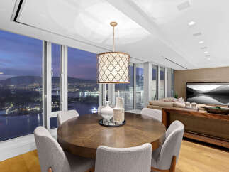 This luxurious condo boasts breathtaking panoramic city views from its floor-to-ceiling windows, creating a bright and airy atmosphere.
