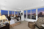 Luxury penthouse bedroom with breathtaking city views.
