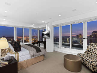 Luxury penthouse bedroom with breathtaking city views.