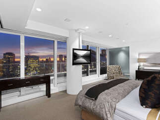 Luxury high-rise condo with breathtaking city views from floor-to-ceiling windows.