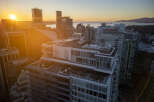 Luxury penthouse with expansive rooftop terrace offering breathtaking sunset views over the city skyline and ocean.