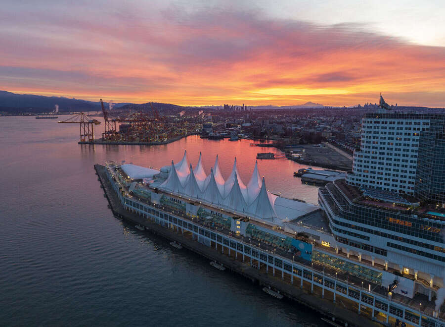 Panoramic view of Canada Place in Vancouver, British Columbia, during a vibrant sunrise.