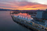 Panoramic view of Canada Place in Vancouver, British Columbia, during a vibrant sunrise.