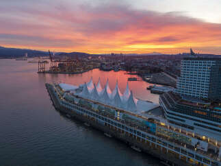 Panoramic view of Canada Place in Vancouver, British Columbia, during a vibrant sunrise.