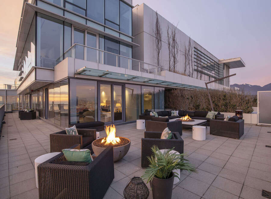 This luxurious penthouse boasts a spacious outdoor patio with a fire pit, perfect for entertaining guests or enjoying a quiet evening.