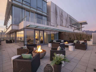 This luxurious penthouse boasts a spacious outdoor patio with a fire pit, perfect for entertaining guests or enjoying a quiet evening.