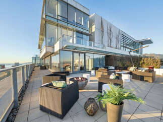 This luxurious penthouse boasts a spacious outdoor patio perfect for entertaining, complete with a fire pit, comfortable seating, and stunning city views.