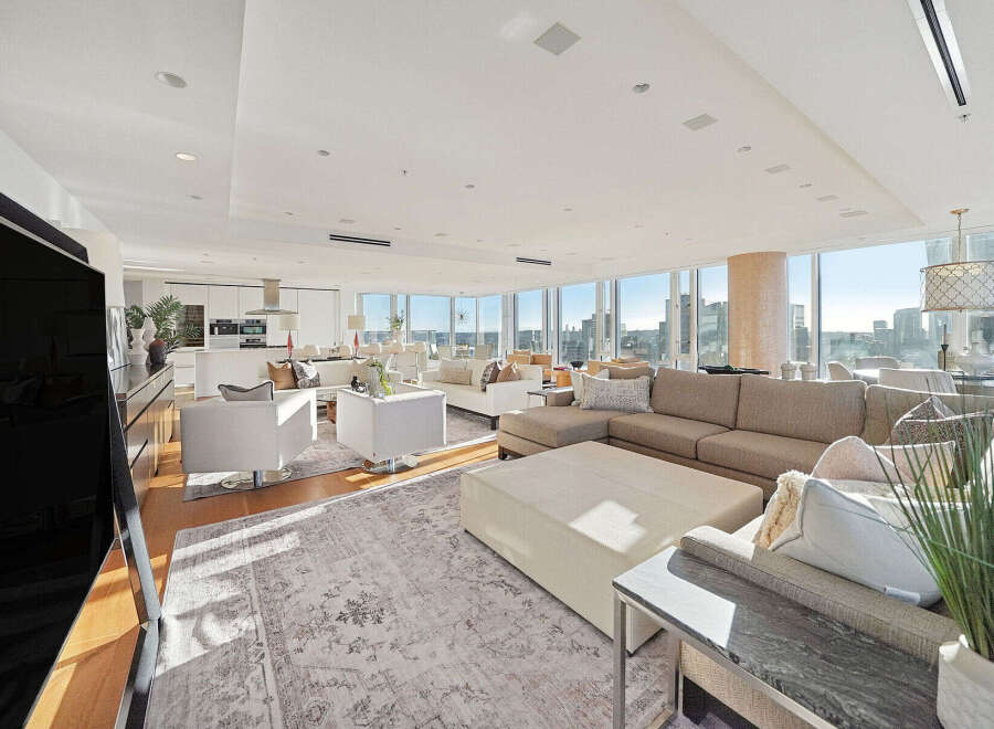 This luxurious penthouse boasts breathtaking city views from its expansive windows, creating a bright and airy atmosphere.