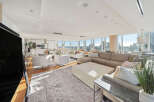 This luxurious penthouse boasts breathtaking city views from its expansive windows, creating a bright and airy atmosphere.