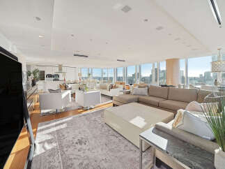 This luxurious penthouse boasts breathtaking city views from its expansive windows, creating a bright and airy atmosphere.