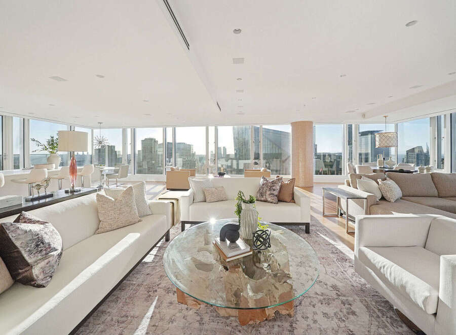 This luxurious penthouse boasts breathtaking panoramic city views from its wall-to-wall windows, creating an open and airy atmosphere.