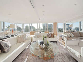This luxurious penthouse boasts breathtaking panoramic city views from its wall-to-wall windows, creating an open and airy atmosphere.