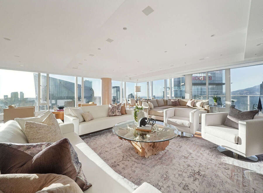 This luxurious penthouse boasts breathtaking panoramic city views from its floor-to-ceiling windows, creating an open and airy atmosphere.