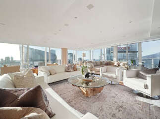 This luxurious penthouse boasts breathtaking panoramic city views from its floor-to-ceiling windows, creating an open and airy atmosphere.