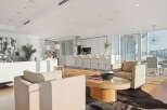 This luxurious condo boasts an open-concept living space with floor-to-ceiling windows offering breathtaking city views.