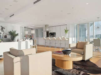 This luxurious condo boasts an open-concept living space with floor-to-ceiling windows offering breathtaking city views.
