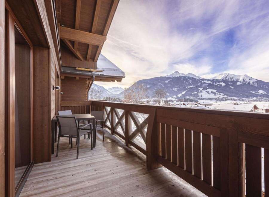 This property features a charming wooden balcony with stunning mountain views, perfect for enjoying the serene alpine setting.