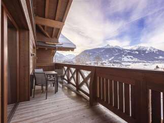 This property features a charming wooden balcony with stunning mountain views, perfect for enjoying the serene alpine setting.