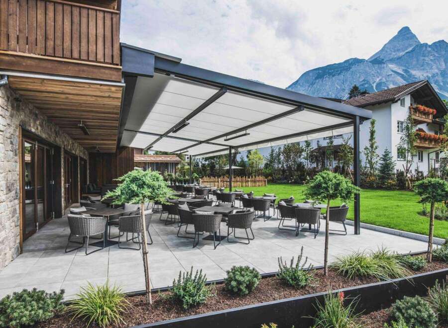 This property features an inviting outdoor terrace with modern patio furniture, perfect for enjoying the scenic mountain views.
