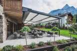 This property features an inviting outdoor terrace with modern patio furniture, perfect for enjoying the scenic mountain views.