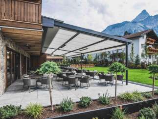 This property features an inviting outdoor terrace with modern patio furniture, perfect for enjoying the scenic mountain views.