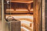 This sauna features wood-paneled walls and benches with warm lighting, perfect for relaxation.