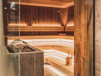 This sauna features wood-paneled walls and benches with warm lighting, perfect for relaxation.