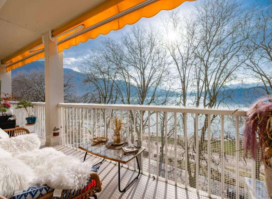 This stunning balcony boasts breathtaking lake views, enhanced by a retractable awning for sun protection.