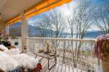 This stunning balcony boasts breathtaking lake views, enhanced by a retractable awning for sun protection.