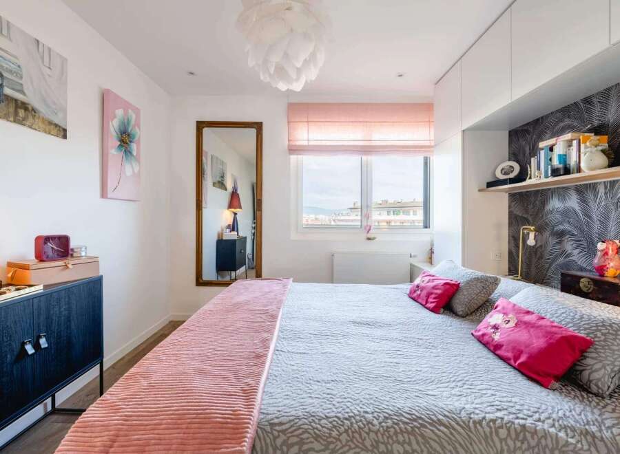 Stylish bedroom with a comfortable king-size bed, built-in shelving, and large window offering scenic views.