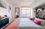 Stylish bedroom with a comfortable king-size bed, built-in shelving, and large window offering scenic views.