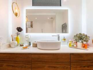 This stunning bathroom boasts a modern design with walnut cabinetry and a sleek white sink.