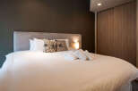 Relax in this cozy bedroom featuring a comfortable double bed, plush pillows, and neatly folded towels.