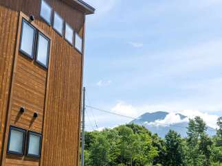 This stunning property boasts a modern design with a rustic wooden exterior, complemented by large windows offering breathtaking views of the surrounding landscape.