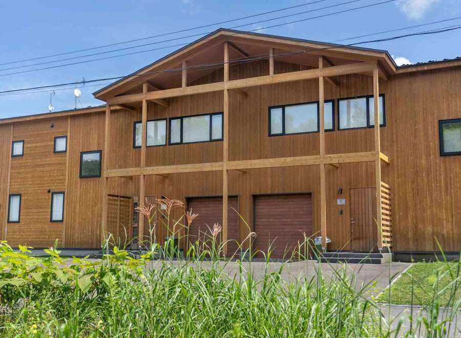 This stunning modern home boasts a sleek, contemporary design with a wood exterior, creating a warm and inviting atmosphere.