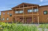 This stunning modern home boasts a sleek, contemporary design with a wood exterior, creating a warm and inviting atmosphere.