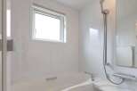 This modern bathroom boasts a sleek, white design with a built-in bathtub and shower combination.