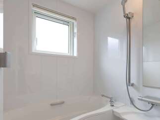 This modern bathroom boasts a sleek, white design with a built-in bathtub and shower combination.