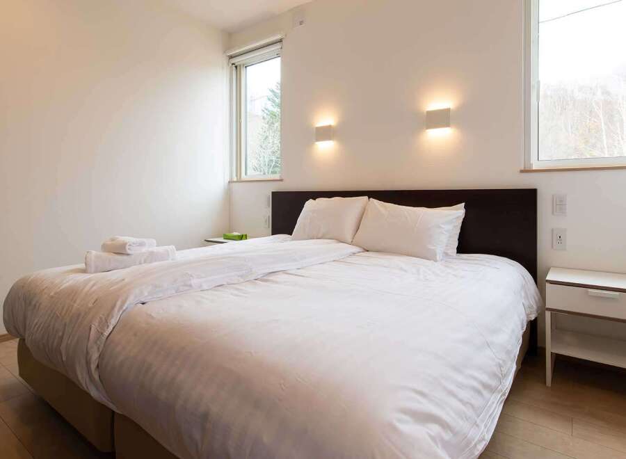 This bright and airy bedroom features a comfortable double bed with crisp white linens, perfect for a relaxing stay.