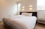 This bright and airy bedroom features a comfortable double bed with crisp white linens, perfect for a relaxing stay.