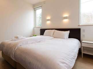 This bright and airy bedroom features a comfortable double bed with crisp white linens, perfect for a relaxing stay.