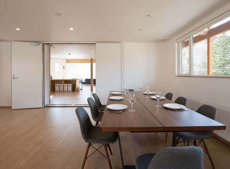 This modern dining area features a sleek, dark wood table surrounded by stylish gray chairs, perfect for enjoying meals with a view.