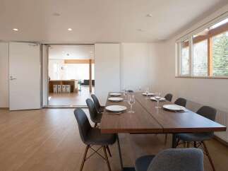 This modern dining area features a sleek, dark wood table surrounded by stylish gray chairs, perfect for enjoying meals with a view.