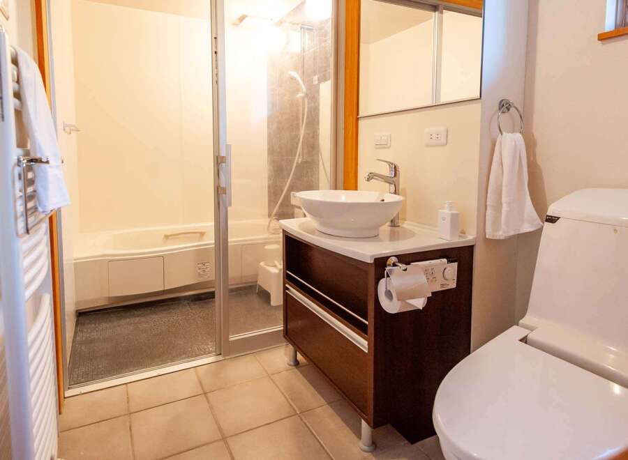 This cozy bathroom boasts a modern toilet and sink, a relaxing bathtub perfect for soaking, and a shower for a quick rinse.
