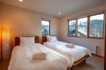 This cozy bedroom features two twin beds with crisp white linens and fluffy towels, perfect for a relaxing stay.