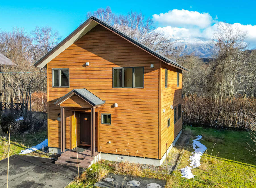This charming two-story house boasts a warm wood exterior, perfect for a cozy mountain getaway.