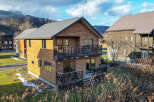 This charming two-story wooden house boasts a spacious balcony and deck, perfect for enjoying mountain views.