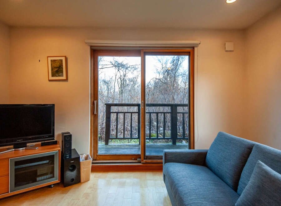 This cozy living room features a comfortable sofa, perfect for relaxing and enjoying the view through the sliding glass doors.