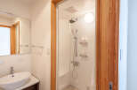 This modern bathroom boasts a sleek, white shower stall with built-in shelving for toiletries and a comfortable seat.